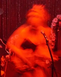 A blurry image of a young lady on stage - Bleached.